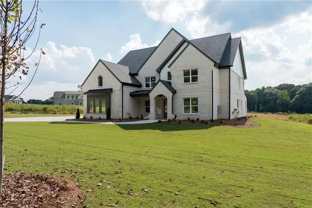 a front view of a house with yard and green space