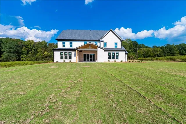 a front view of a house with yard and green space