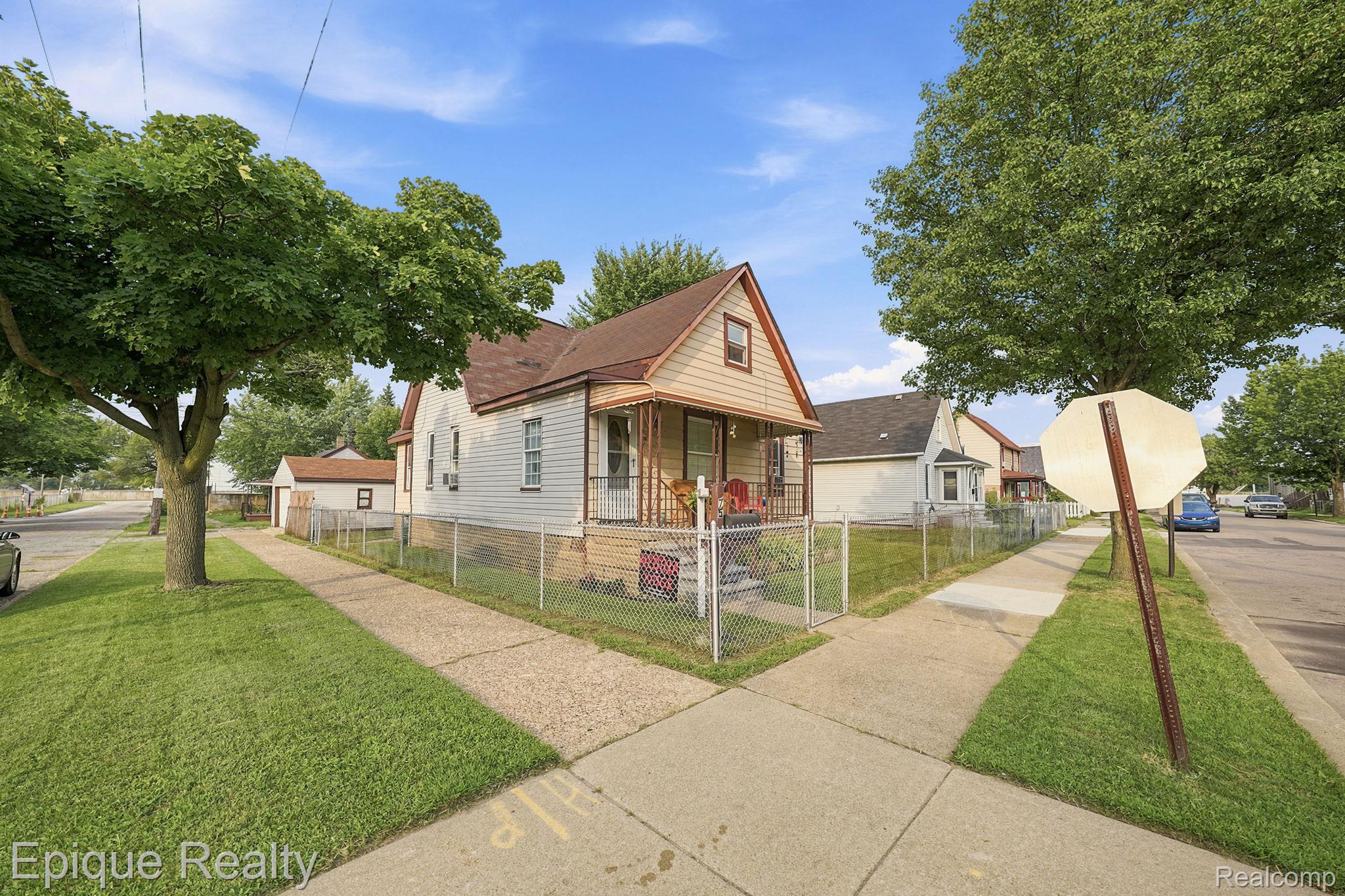 75 East Cicotte Street River Rouge, MI 48218 - Photo 3 of 25 Corner lot property featuring a light-colored siding exterior, a covered front porch, and a fenced yard