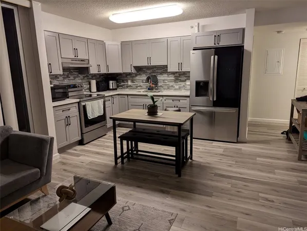 a kitchen with stainless steel appliances a refrigerator a stove a sink and white cabinets