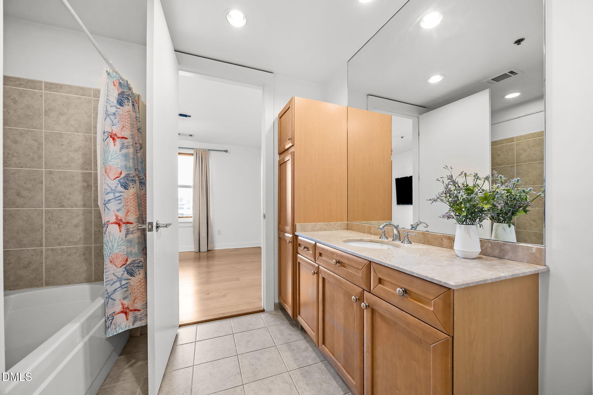 618 North Boylan Avenue, Unit 702 Raleigh, NC 27603 - Photo 29 of 42 a bathroom with a double vanity sink a large mirror and a bathtub