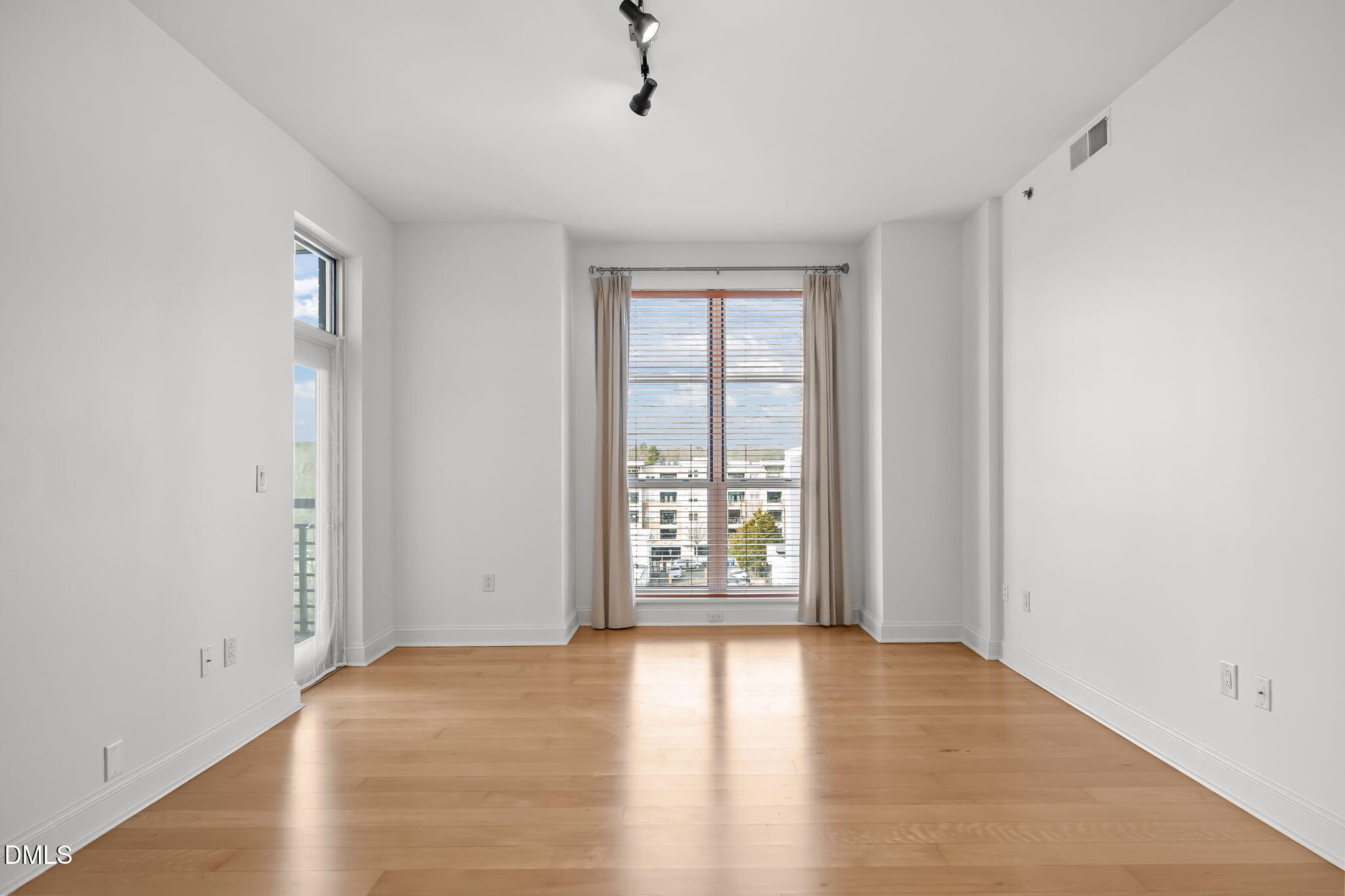 618 North Boylan Avenue, Unit 702 Raleigh, NC 27603 - Photo 3 of 42 an empty room with wooden floor and windows