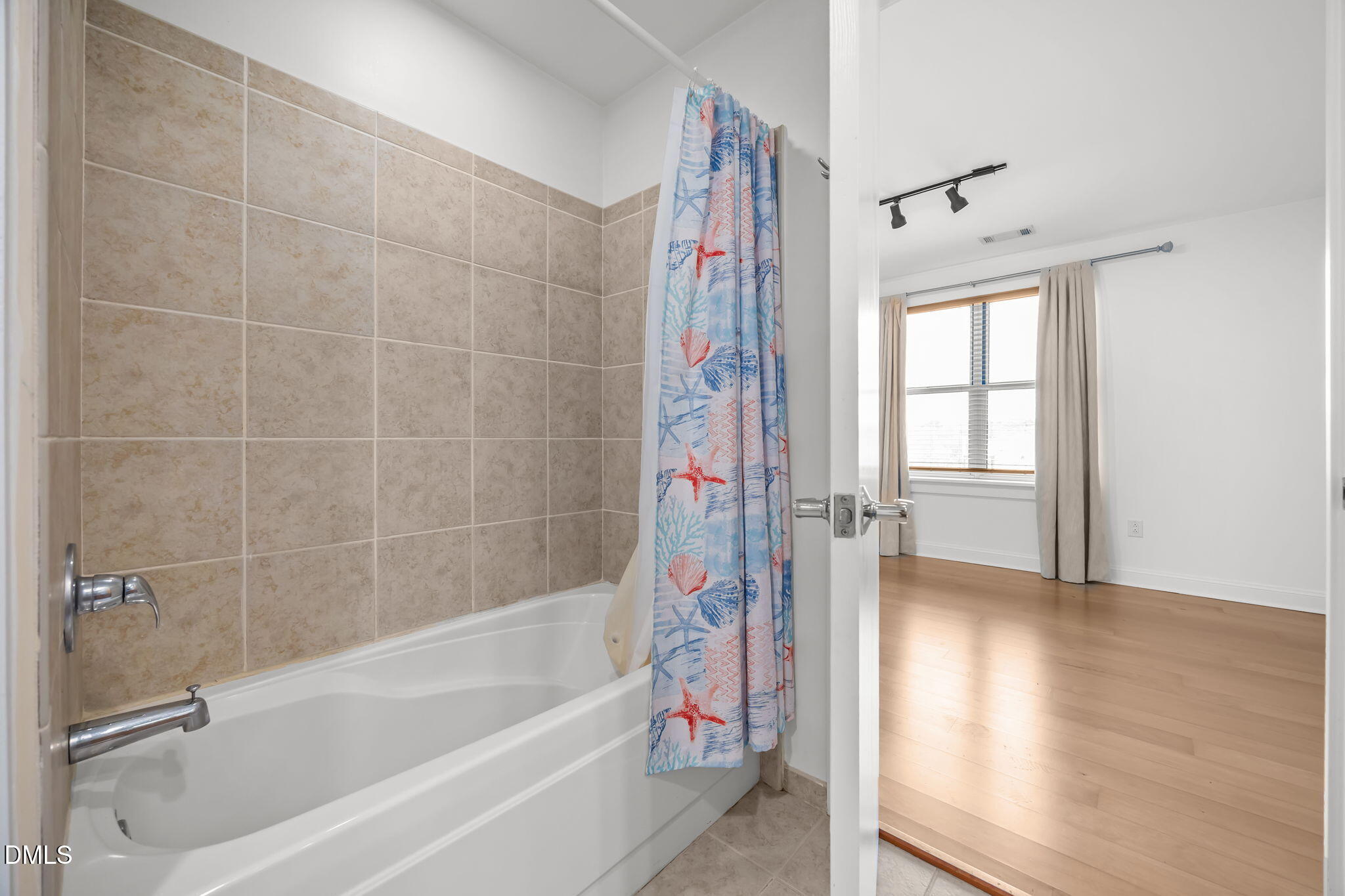 618 North Boylan Avenue, Unit 702 Raleigh, NC 27603 - Photo 31 of 42 a bathroom with a bathtub a shower and a window