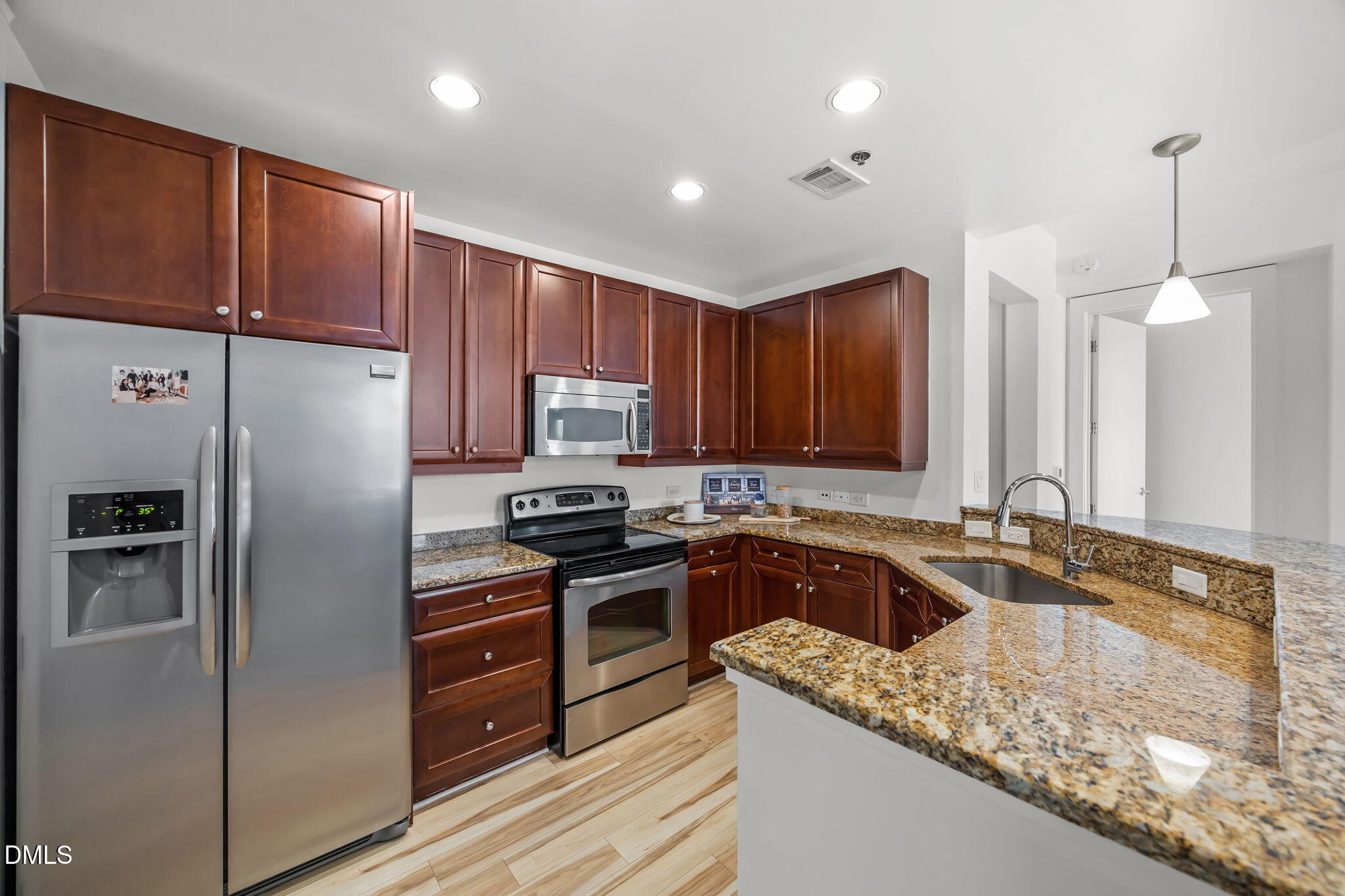 618 North Boylan Avenue, Unit 702 Raleigh, NC 27603 - Photo 9 of 42 a kitchen with granite countertop stainless steel appliances a refrigerator a stove a sink cabinets and a center island