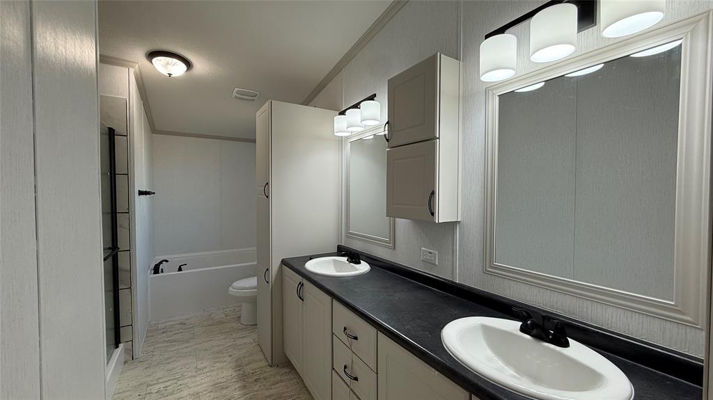 244 Overland Trail Runaway Bay, TX 76426 - Photo 10 of 15 a bathroom with a sink a toilet and a mirror