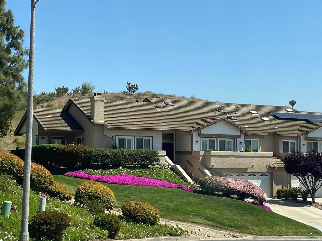 a front view of a house with a big yard and potted plants