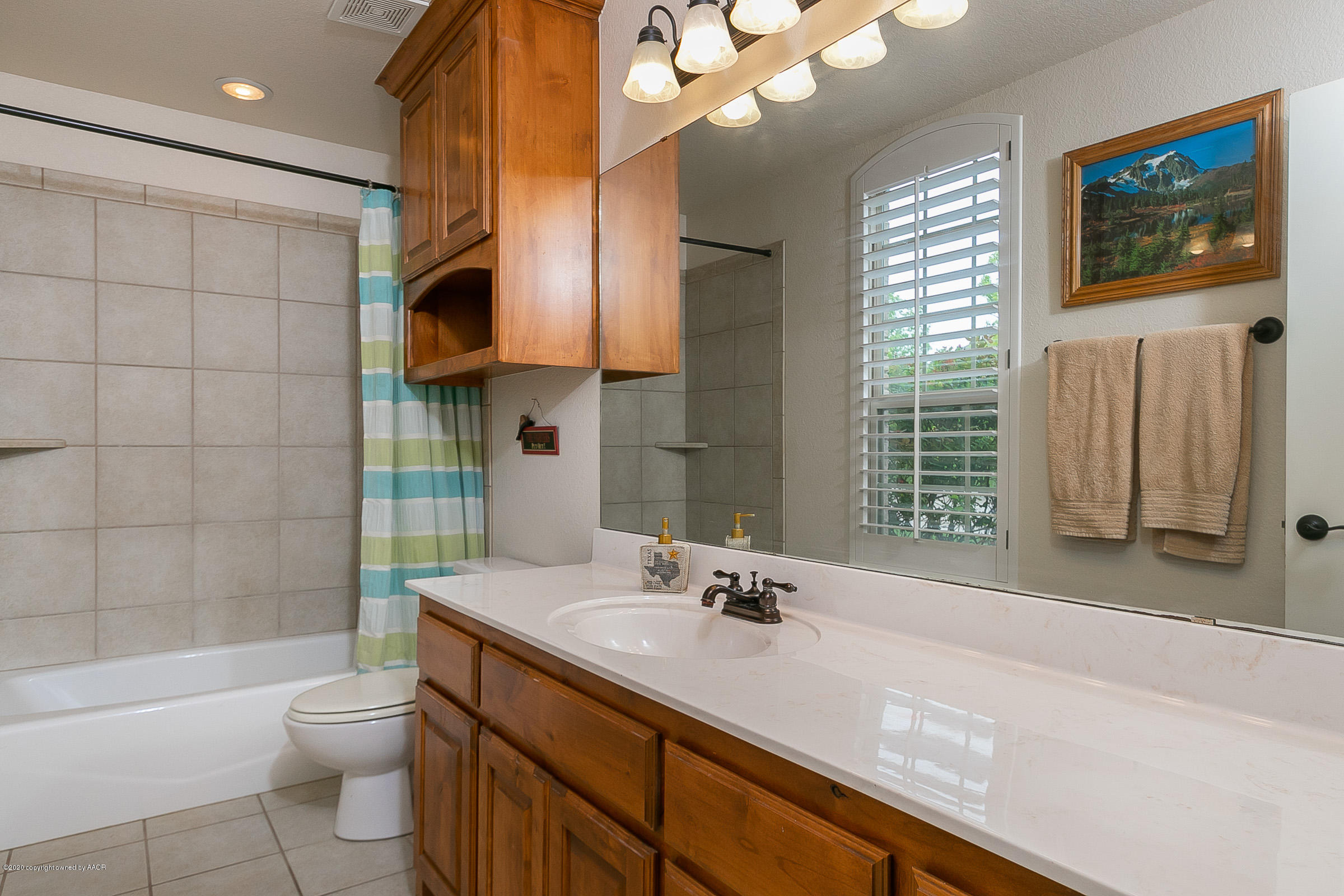 7411 Countryside Drive Amarillo, TX 79119 - Photo 22 of 39 a bathroom with a granite countertop sink a toilet a mirror and shower