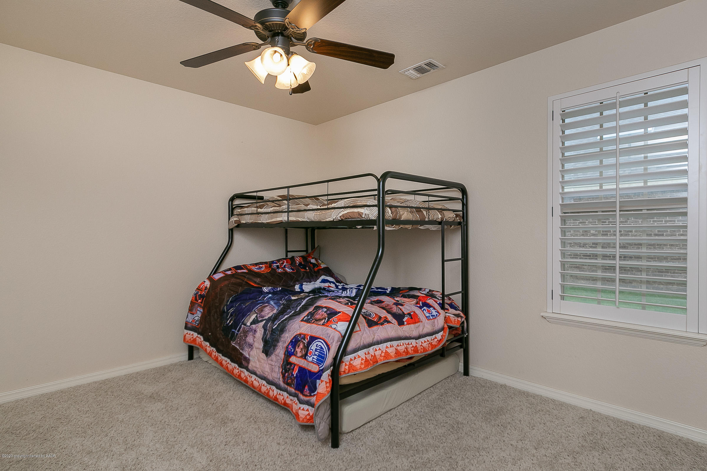7411 Countryside Drive Amarillo, TX 79119 - Photo 23 of 39 a bedroom with a bed and a chandelier
