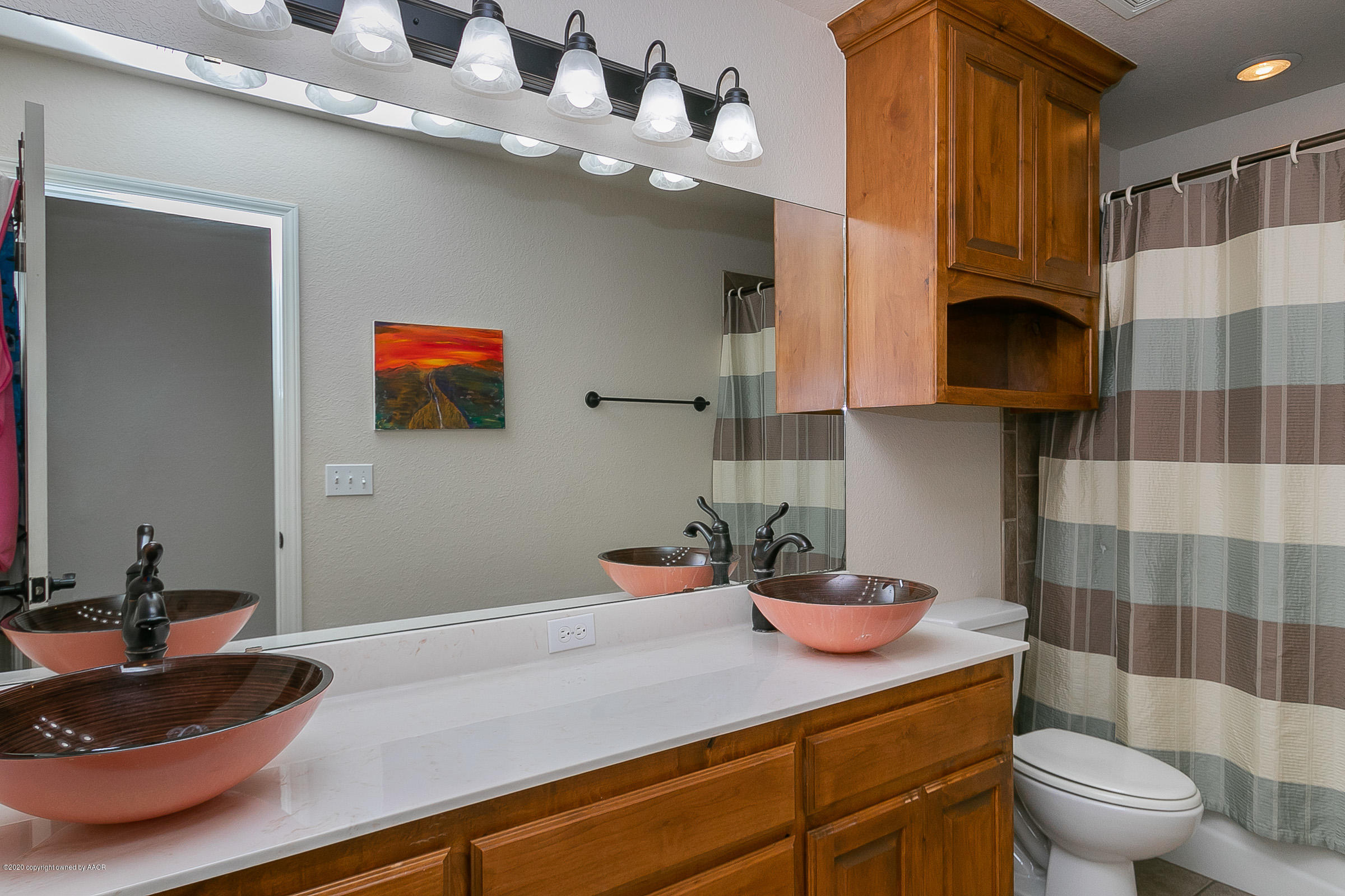 7411 Countryside Drive Amarillo, TX 79119 - Photo 24 of 39 a bathroom with a sink a toilet and shower curtain