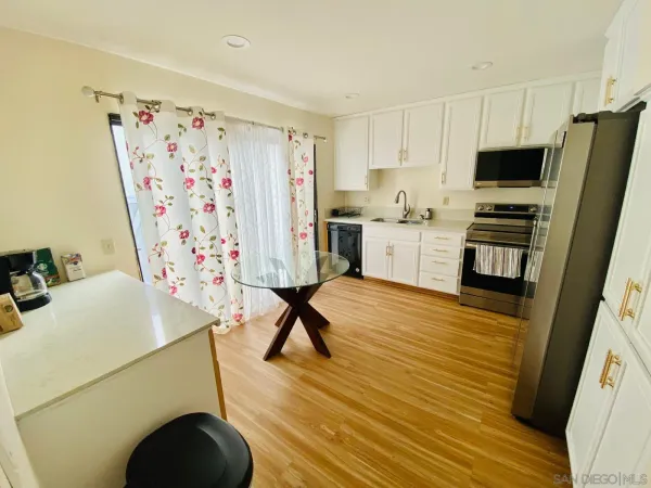 a kitchen with stainless steel appliances a stove a sink a refrigerator a microwave and cabinets