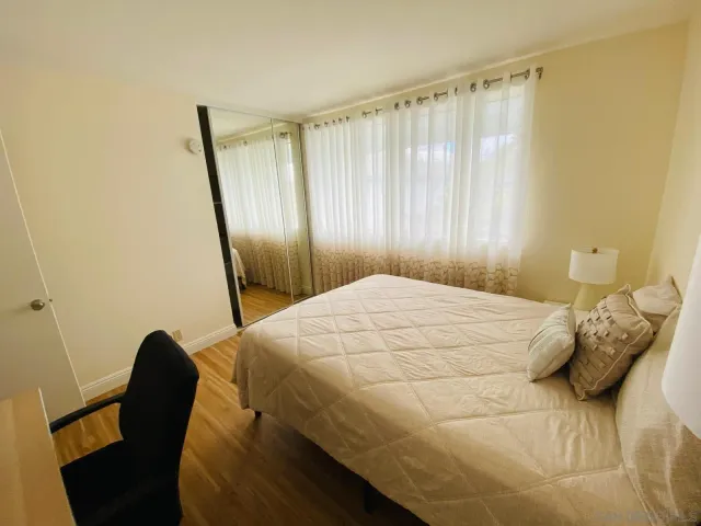 a bedroom with a bed and wooden floor