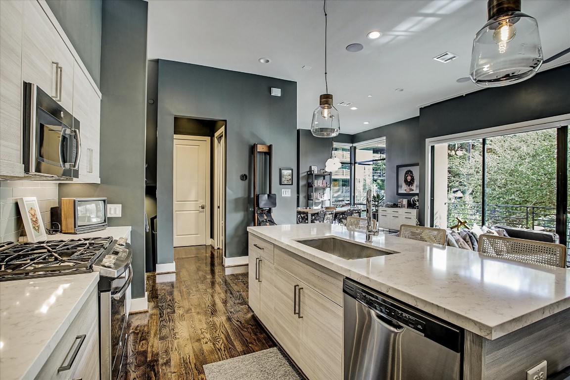 1004 California Street, Unit 101 Houston, TX 77006 - Photo 14 of 27 a kitchen with stainless steel appliances granite countertop a sink a stove and a refrigerator