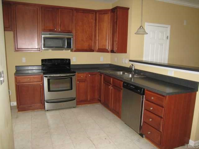2606 Andover Glen Road Raleigh, NC 27604 - Photo 3 of 5 a kitchen with granite countertop stainless steel appliances a stove a sink and a microwave