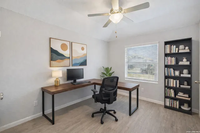 a view of a workspace with furniture and a window