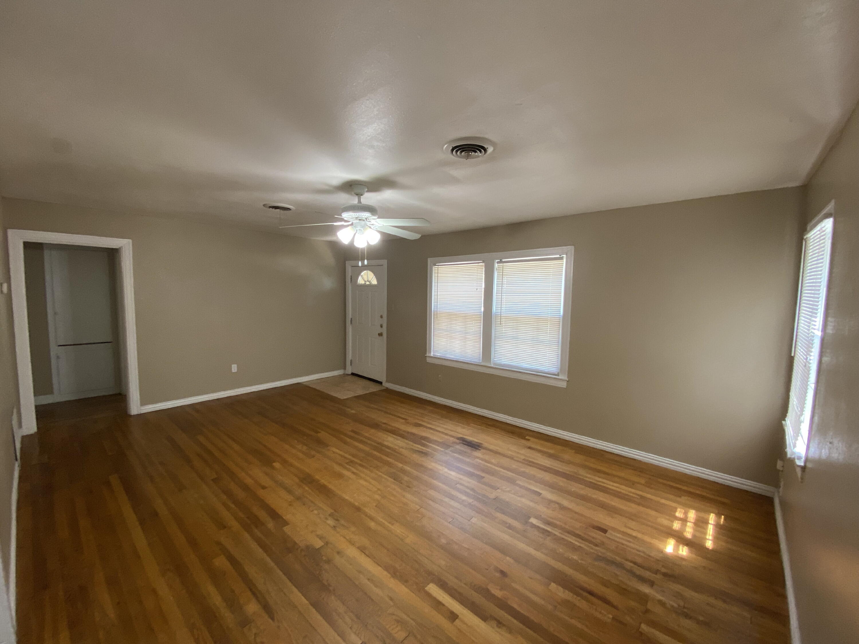 2520 27th Street, Unit FRONT Lubbock, TX 79410 - Photo 3 of 17 a view of an empty room with wooden floor and a window