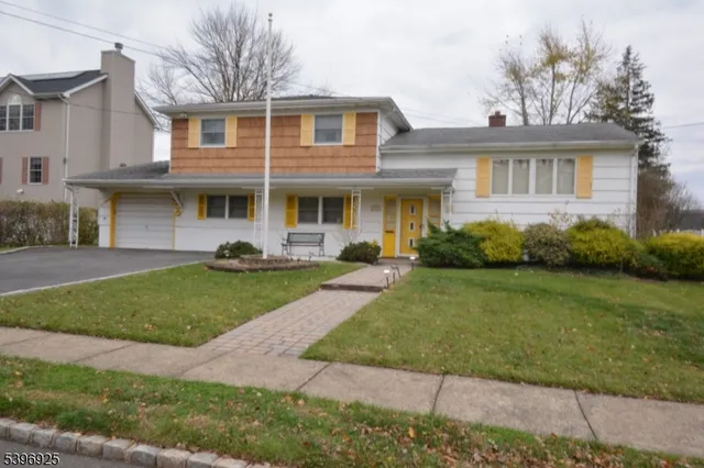 a front view of a house with a garden and plants