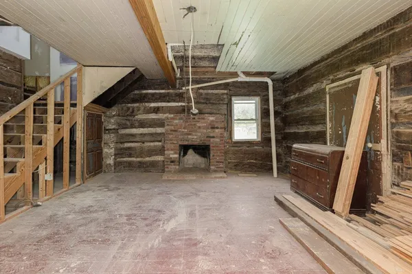 a view of an empty room with wooden floor and windows