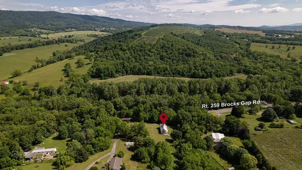 an aerial view of residential house with outdoor space and trees all around
