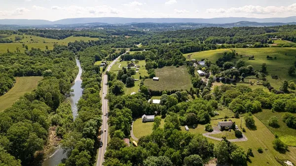 an aerial view of residential house with outdoor space and trees all around