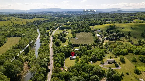 an aerial view of residential house with outdoor space and trees all around