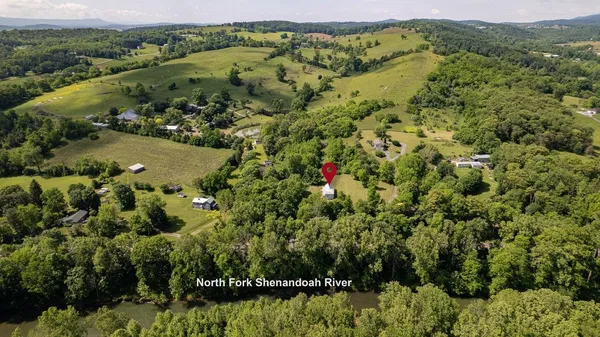 an aerial view of a house with a yard and lake view
