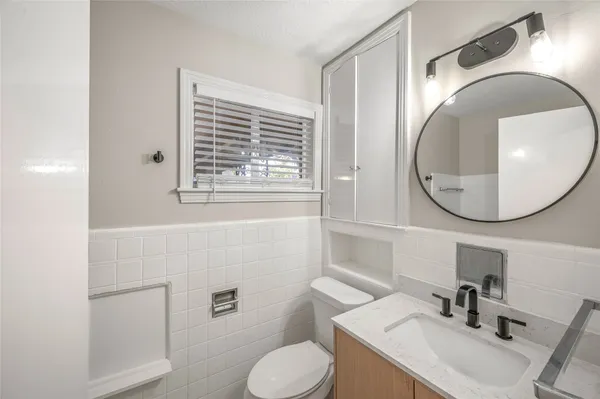 a bathroom with a sink toilet and mirror