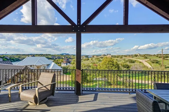 a view of a balcony with wooden floor next to a road
