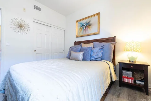 a bedroom with a bed and a painting on the wall