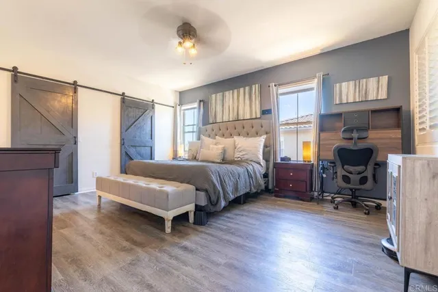 a bedroom with a bed a chair and a chandelier