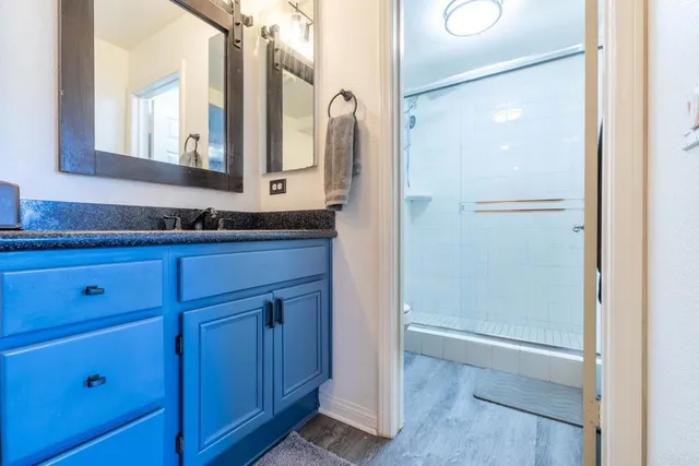 a bathroom with a granite countertop sink and a mirror