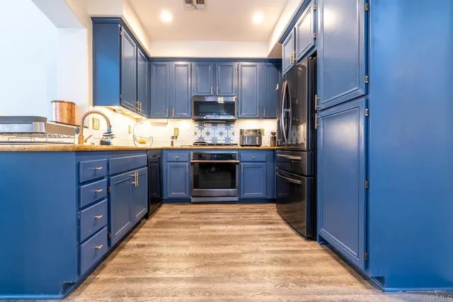 a kitchen with granite countertop stainless steel appliances and wooden cabinets