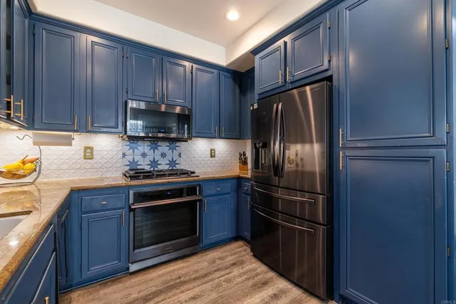 a kitchen with granite countertop wooden cabinets and stainless steel appliances
