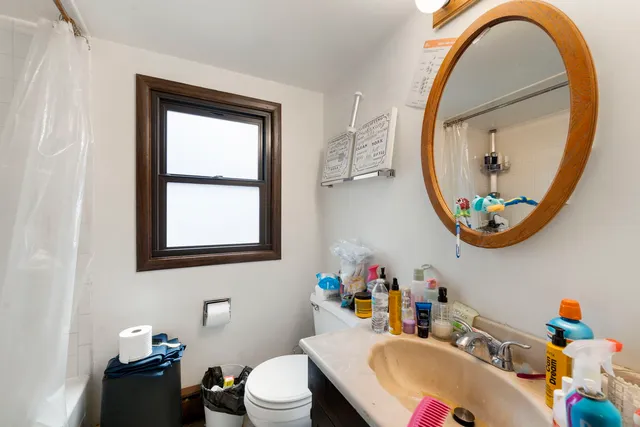 a bathroom with a sink mirror and toilet