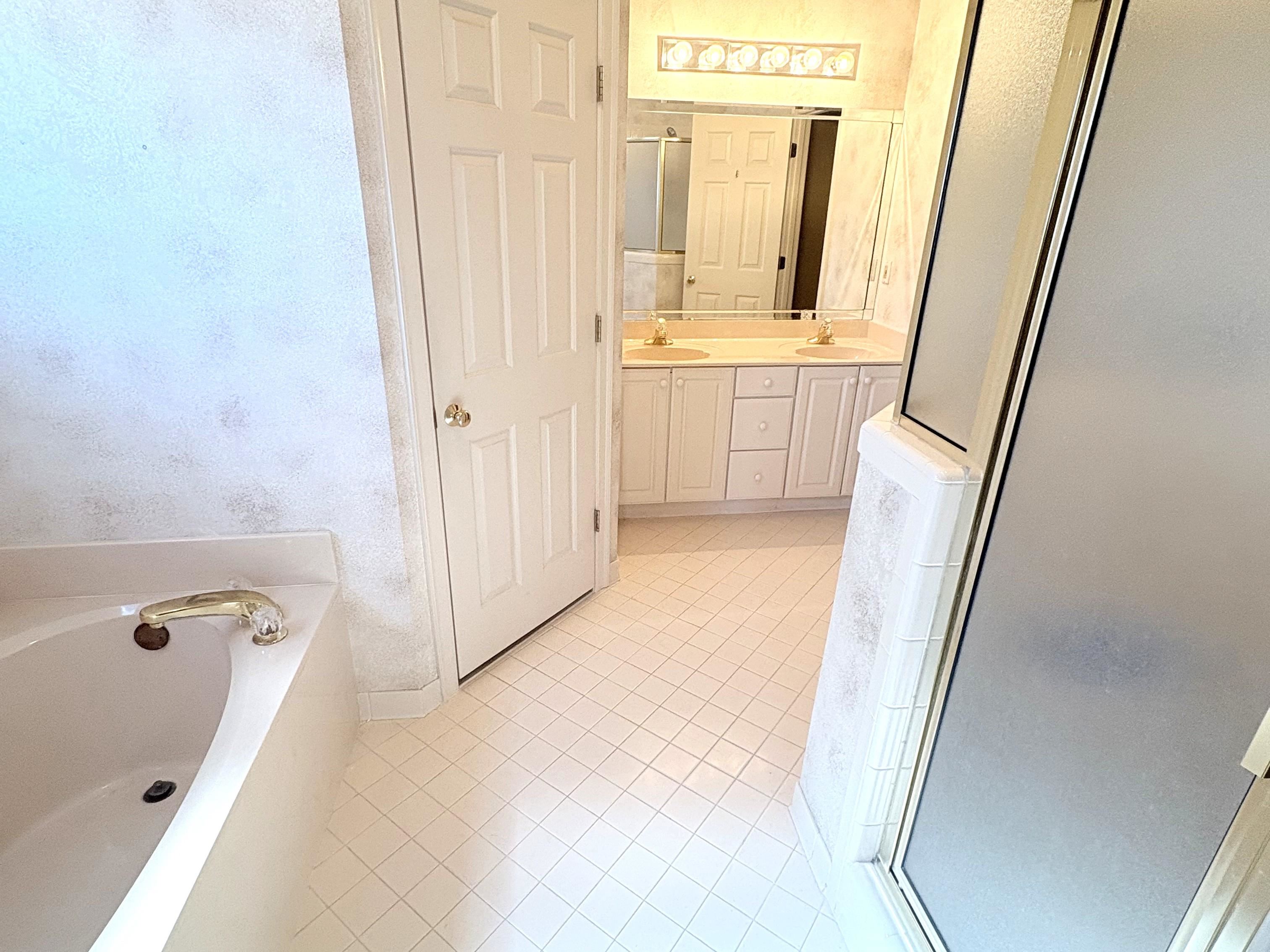 1740 Constable Court Collierville, TN 38017 - Photo 11 of 17 Full bath with double vanity, a shower stall, light tile patterned floors, and a jacuzzi tub.