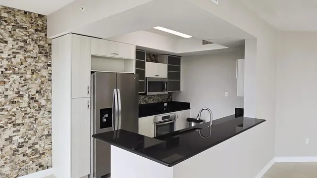 a kitchen with stainless steel appliances a sink and refrigerator