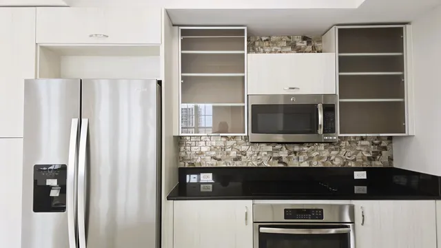 a view of kitchen with a refrigerator and cabinets