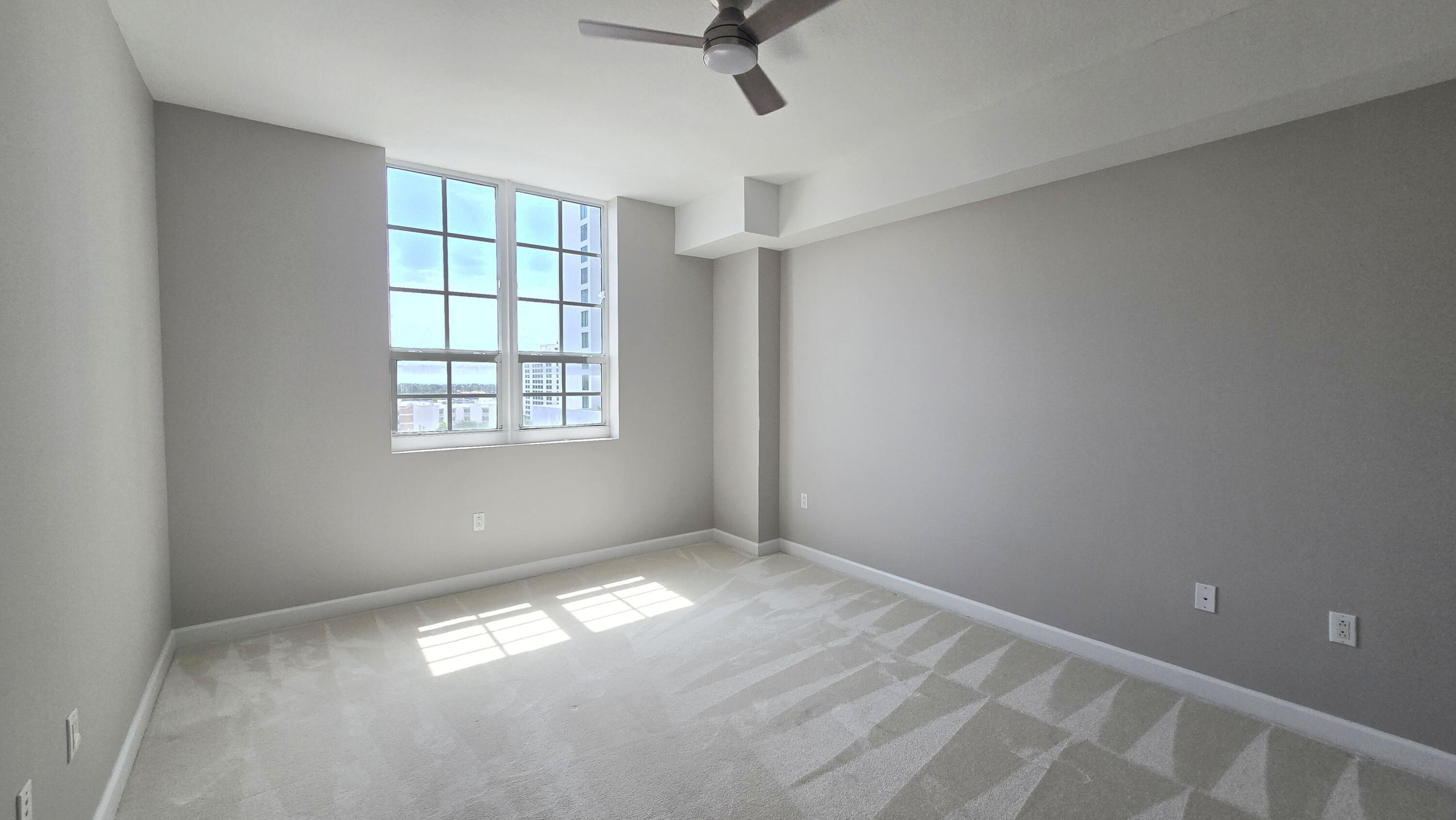 410 Evernia Street, Unit 701 West Palm Beach, FL 33401 - Photo 9 of 29 an empty room with windows and fan