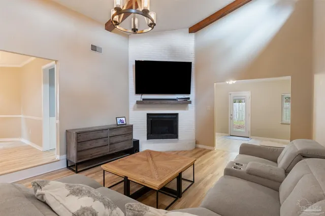 a living room with furniture a flat screen tv and a fireplace