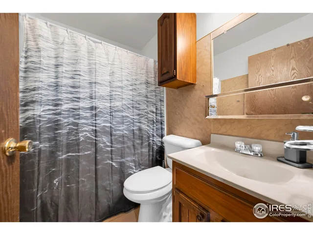 a bathroom with a sink a toilet and shower curtain