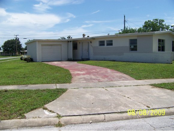 3098 Northeast Inwood Palm Bay, FL 32905 - Photo 1 of 11 a front view of a house with a yard and garage