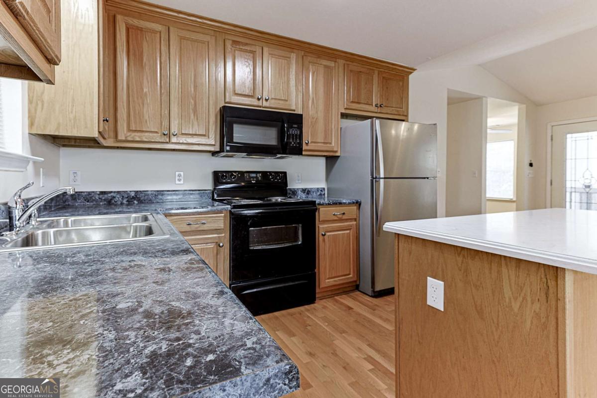 30 Chancel Circle, Unit 654R Ellijay, GA 30540 - Photo 12 of 44 a kitchen with granite countertop a refrigerator stove and microwave