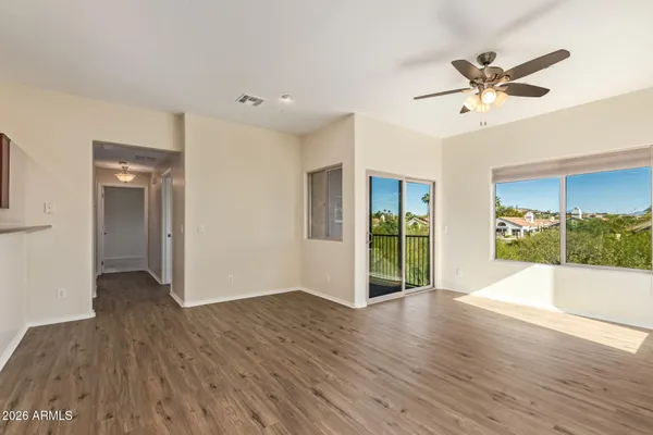 a view of a livingroom with wooden floor and a ceiling fan