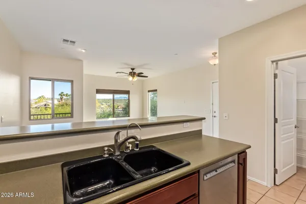 a large kitchen with stainless steel appliances wooden cabinets and a refrigerator