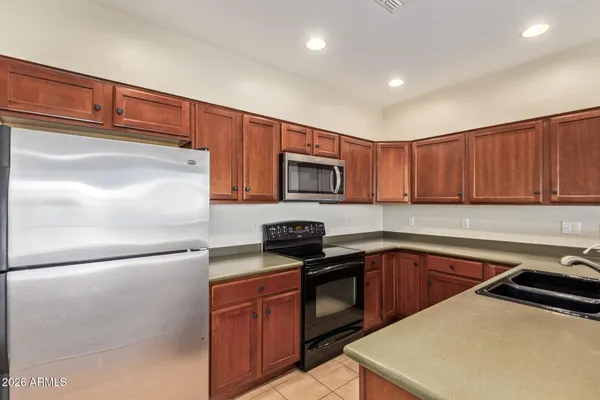 a kitchen with stainless steel appliances granite countertop a refrigerator sink and stove