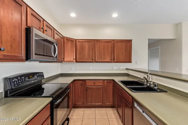 a kitchen with stainless steel appliances a sink a stove and cabinets