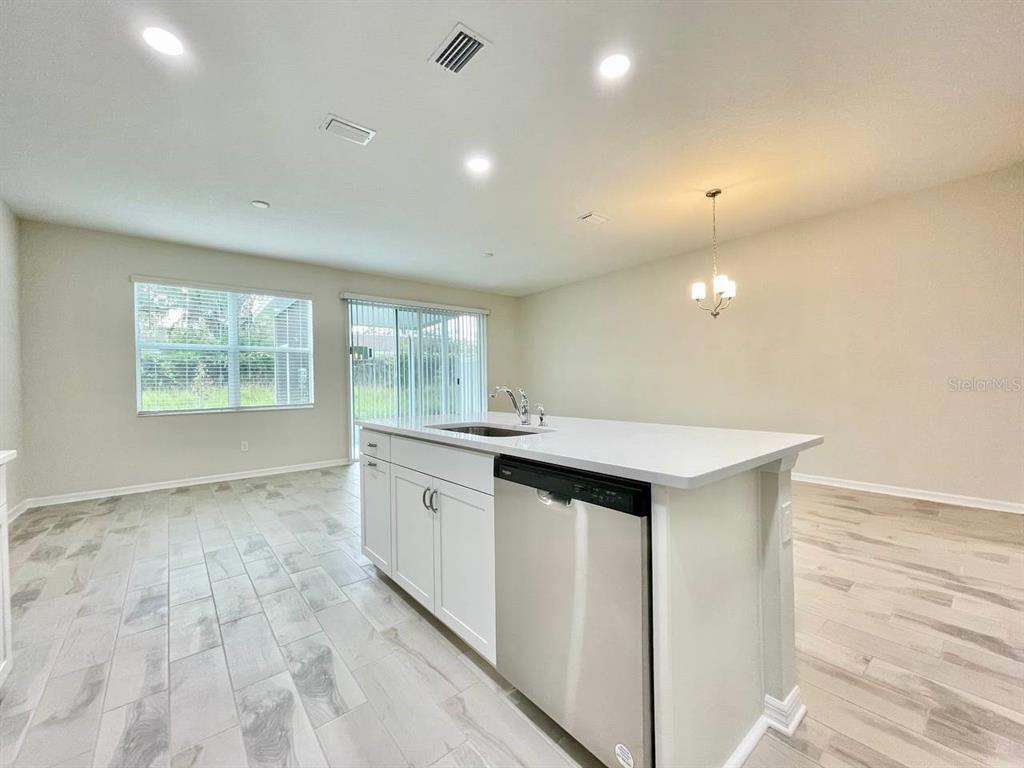 9689 Sweetwell Place Riverview, FL 33569 - Photo 11 of 33 a kitchen with kitchen island a sink and wooden floor