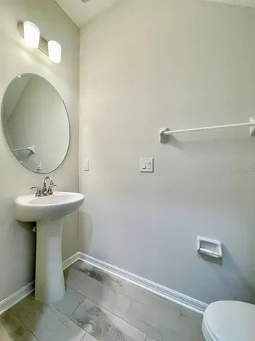 a bathroom with a sink toilet and mirror