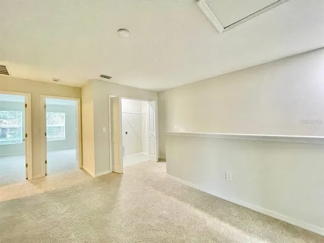an empty room with cabinet and mirrors