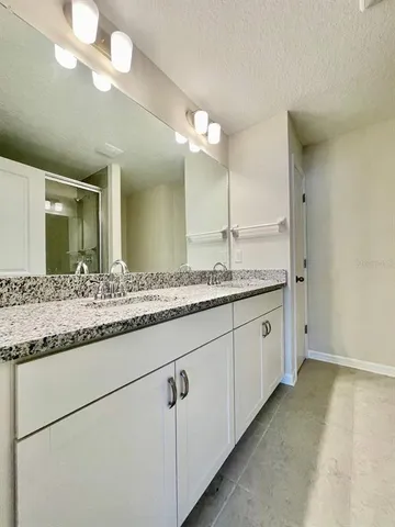 a bathroom with a granite countertop sink and a mirror