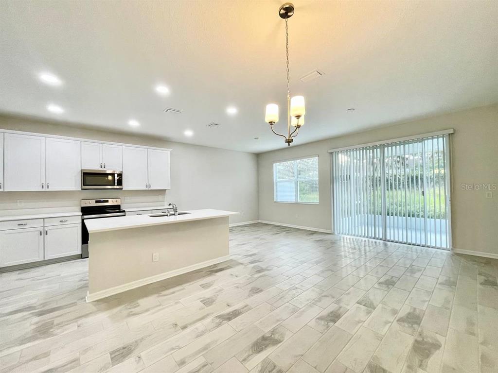 9689 Sweetwell Place Riverview, FL 33569 - Photo 5 of 33 a large kitchen with kitchen island a sink stainless steel appliances and a chandelier